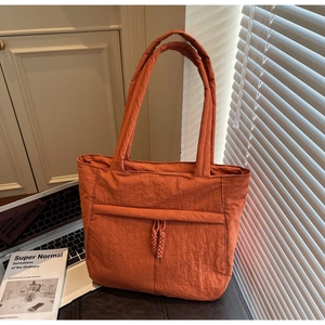 Detailansicht der orangefarbenen gesteppten Nylon-Tasche mit Kordelzug in modernem Dekor