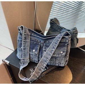 Vue détaillée du sac en jean délavé vintage avec poches à boutons métalliques argentés