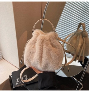 Detail of plush faux fur bucket bag in soft pink beige with drawstring and leather handle