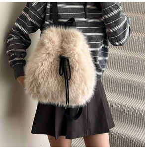 Detail of soft cream faux fur texture on woman's plush backpack with black drawstrings
