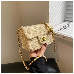 Close-up of quilted tweed mini bag featuring gold ball chain adjuster and metal clasp