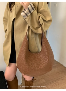 Detailed view of large retro leopard print hobo bucket bag in brown faux leather finish