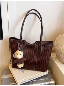 Deep brown woven tote bag with contrast stitching and teddy bear charm for daily use