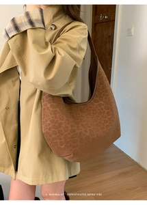 Close-up of leopard print hobo shoulder bag featuring soft faux suede texture and wide strap