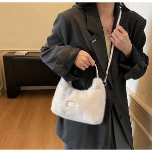 Detailed view of the white plush crossbody bag with Love Every Day embroidery and metal clips