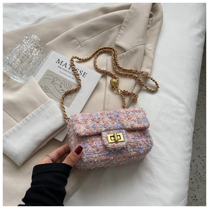 Detail of pink tweed mini bag with golden rotary lock and adjustable ball chain