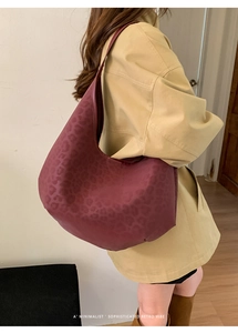 Sophisticated burgundy leopard print tote bag shown on a model for casual retro style