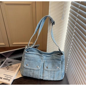 Détail du sac à épaule en jean bleu clair avec poches à pression et design vintage Y2K