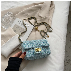 Detail of tweed crossbody bag with golden turn-lock and adjustable metal chain strap