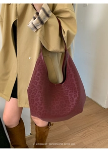Minimalist burgundy retro tote bag with subtle leopard print pattern on a model
