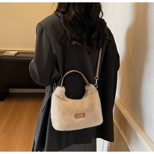 Close-up of fluffy faux fur handbag in beige with adjustable strap and leather patch