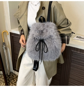 Close-up of grey faux fur backpack featuring black nylon straps and drawstring closure