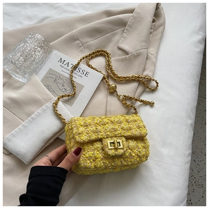 Detail of yellow tweed crossbody bag with gold chain strap and metallic swivel lock