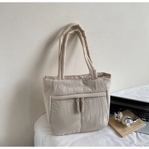 Detailansicht der cremefarbenen Stepp-Tasche mit Kordelzug und großem Fassungsvermögen