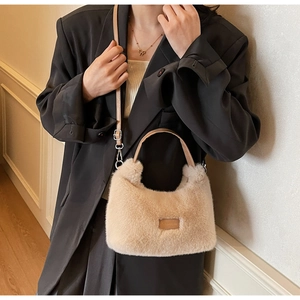 Detail of soft cream faux fur handbag with leather patch and slender crossbody strap