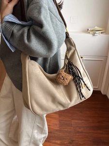 Elegante borsa hobo beige in finto scamosciato con ciondolo a orsetto e tracolla