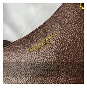 Gros plan sur le cuir grainé marron foncé avec logo doré et détails de couture
