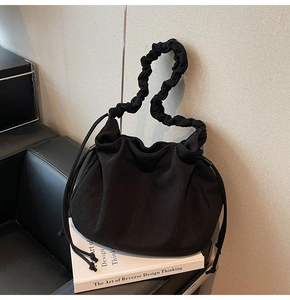 Detail der schwarzen Cord-Tasche mit Raffungen, Kordelzug und gewelltem Schultergurt