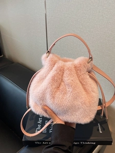 Pink plush faux fur bucket bag with drawstring closure and pink PU leather straps