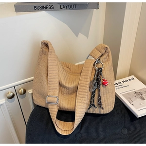 Détail du sac cabas matelassé marron clair avec breloque raquette et large bandoulière