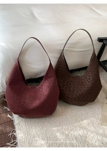 Detail view of large leopard print hobo bags in burgundy and dark brown suede texture
