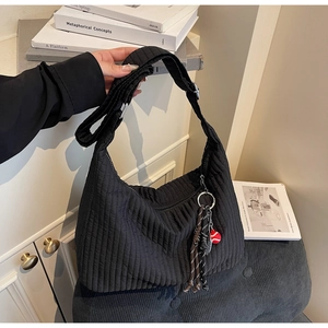 Détail d'un sac à bandoulière matelassé noir avec pendentif en corde tissée créative