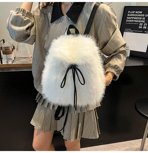 Detailed view of the white plush backpack featuring a decorative black bow and straps