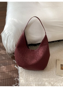 Detail of burgundy leopard print bucket bag with matte finish and large capacity