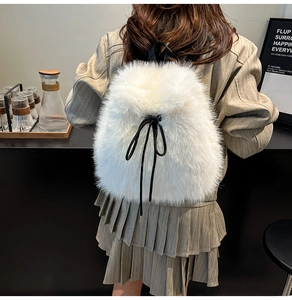 Close-up of white faux fur backpack featuring soft plush texture and black drawstring bow