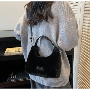 Detail of plush black faux fur tote bag showing the textured fabric and leather straps