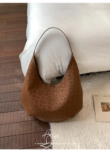 Close-up of retro leopard print hobo bag with suede texture and minimalist shoulder strap