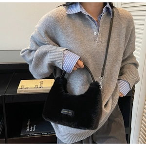 Detail of black faux fur handbag featuring leather handles and love every day tag