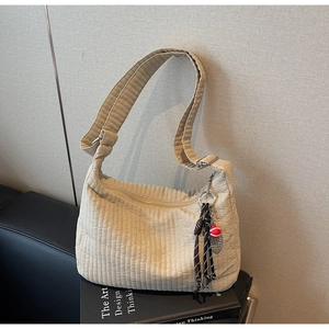 Détail de la texture plissée en nylon beige avec un pendentif balle de tennis créatif