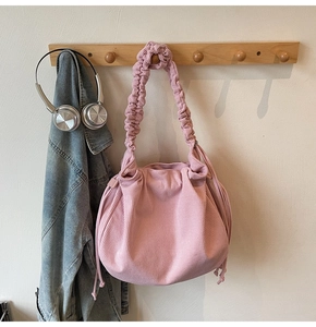 Detail der rosa Cord-Schultertasche mit gerafftem Riemen und Hobo-Stil-Textur