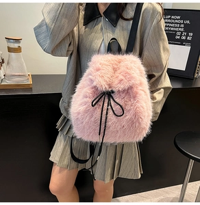 Detail of pink faux fur backpack with black drawstring closure and elegant bow decoration
