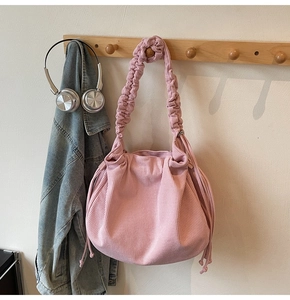 Detail der rosa Cord-Schultertasche mit plissiertem Griff und Tunnelzug-Design