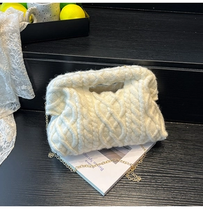 Detailed shot of white cable knit quilted makeup bag with gold metal chain strap