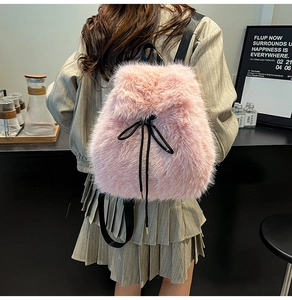 Detail shot of pink faux fur backpack featuring a black drawstring bow and soft texture