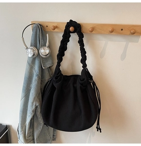 Detail der schwarzen Cord-Schultertasche mit gerüschtem Griff und Tunnelzug-Design