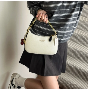White litchi pattern leather baguette bag with gold chain and cherry charm detail