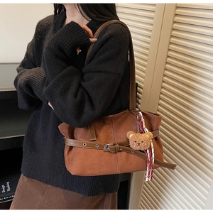 Détail du sac cabas en daim marron avec boucle en cuir et charmant porte-clés ours