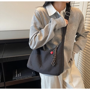 Détail du grand sac cabas plissé noir avec bandoulière réglable et breloque déco