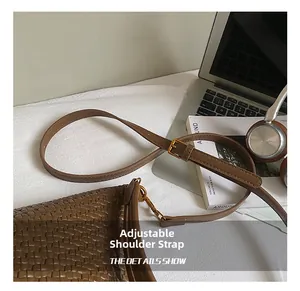 Detail of brown woven leather bag with adjustable strap and gold buckle hardware