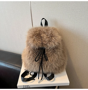 Detail of plush brown backpack featuring fluffy fur texture and black drawstring closure