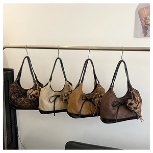 Detail of four quilted underarm bags in brown and leopard print with bow charms