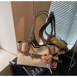 Détail du sac cabas en daim kaki avec garniture en cuir marron et breloque ours en peluche
