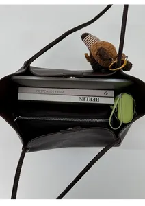 Top view of large brown tote bag showing spacious interior with books and umbrella