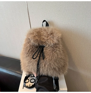Detailed close-up of brown faux fur texture and black drawstring on the plush backpack