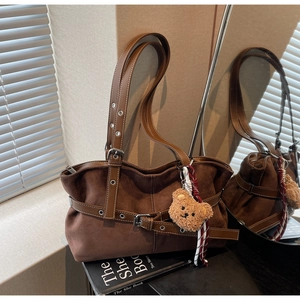 Vue détaillée du sac fourre-tout en daim marron avec boucle et breloque ours en peluche