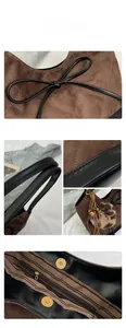 Detail view of brown suede quilted shoulder bag with black leather bow and plush leopard charm